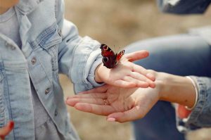 Niña con mariposa en la mano